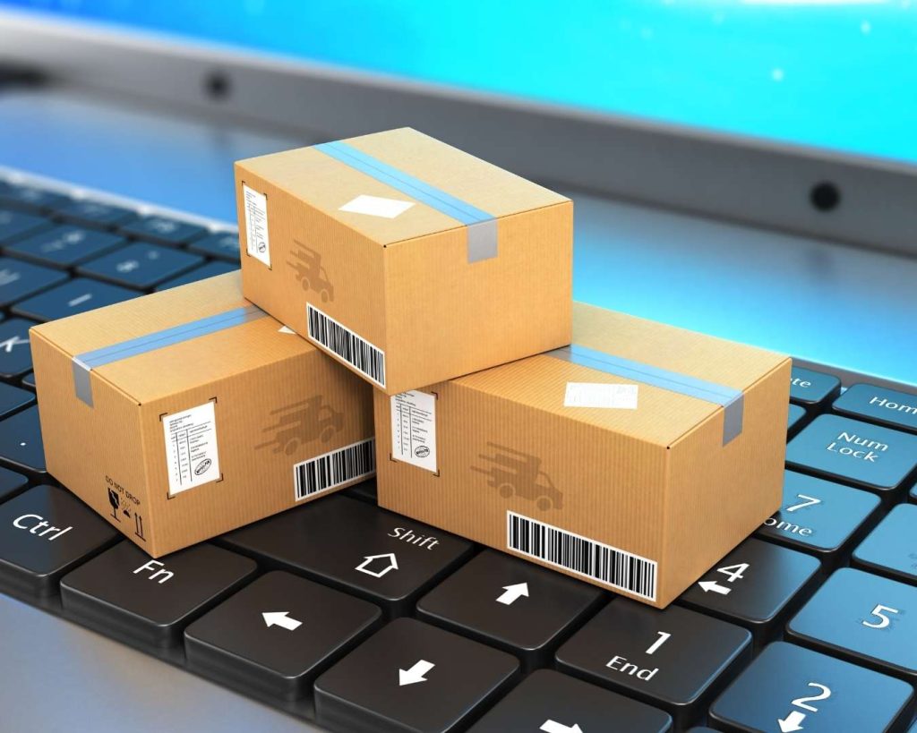 Three small shipping boxes stacked on a laptop keyboard, symbolizing the digital logistics and online shipping optimization services provided by Part n Parcel.